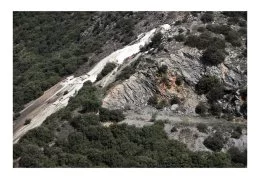 La verse de Narteau constituée de stérile déposé entre 1923 et 1936 sur une pente très prononcée, lourdement chargés en arsenic (120 tonnes au total), sous forme pure par endroits. Totalement dénuée de végétation, la verse de Narteau est bordée à son pied, par un ruisseau, le Grésillou, qui se faufile le long de la cour de l'école de Lastours (voir photo) et se jette dans l'Orbiel.