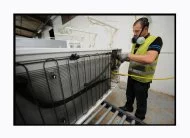 Société Envoi : un technicien traite le recyclage d'un réfrigérateur, démonte le moteur et récupère le fréon. 